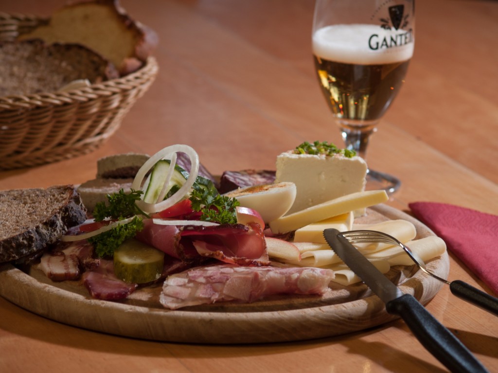 Vesperbrett mit Wurst, Käse und Brot, dazu ein Bier