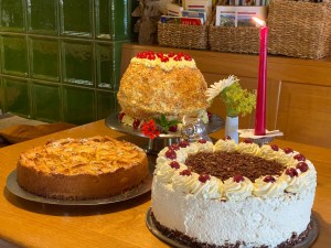 Torten und Kuchen vor dem grünen Kachelofen