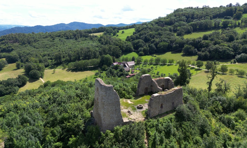 Die Mauern der Ruine Schneeburg aus der Nähe, dahinter der Schönberghof und die Höhen des Schwarzwalds