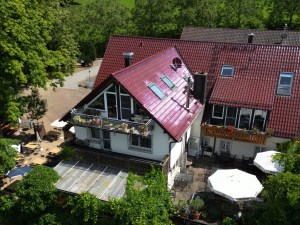 Das Gasthaus Schönberghof aus der Nähe mit Balkon, Terrasse und Sonnenschirmen, Luftaufnahme